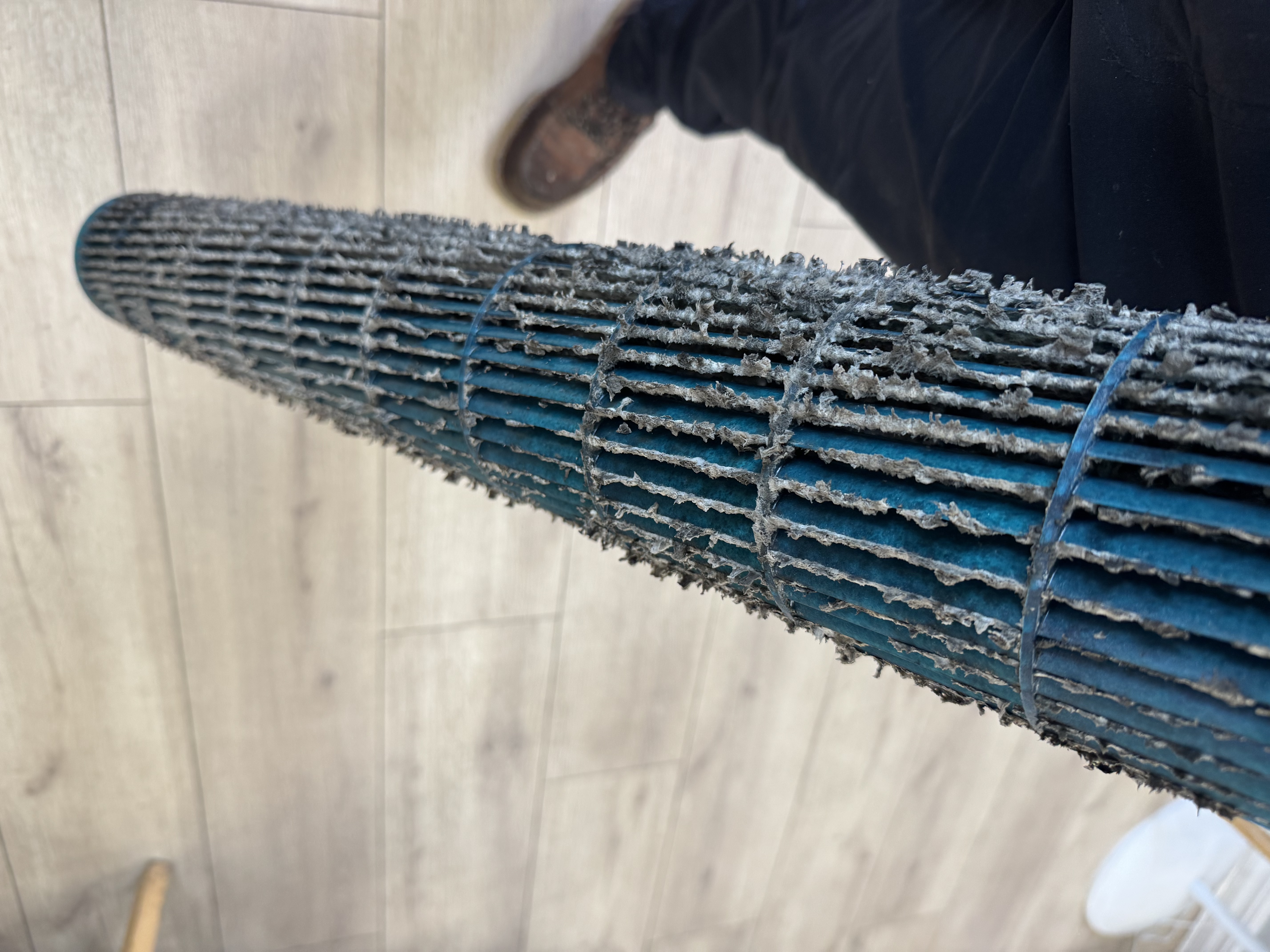Neglected blower wheel caked in dust before cleaning